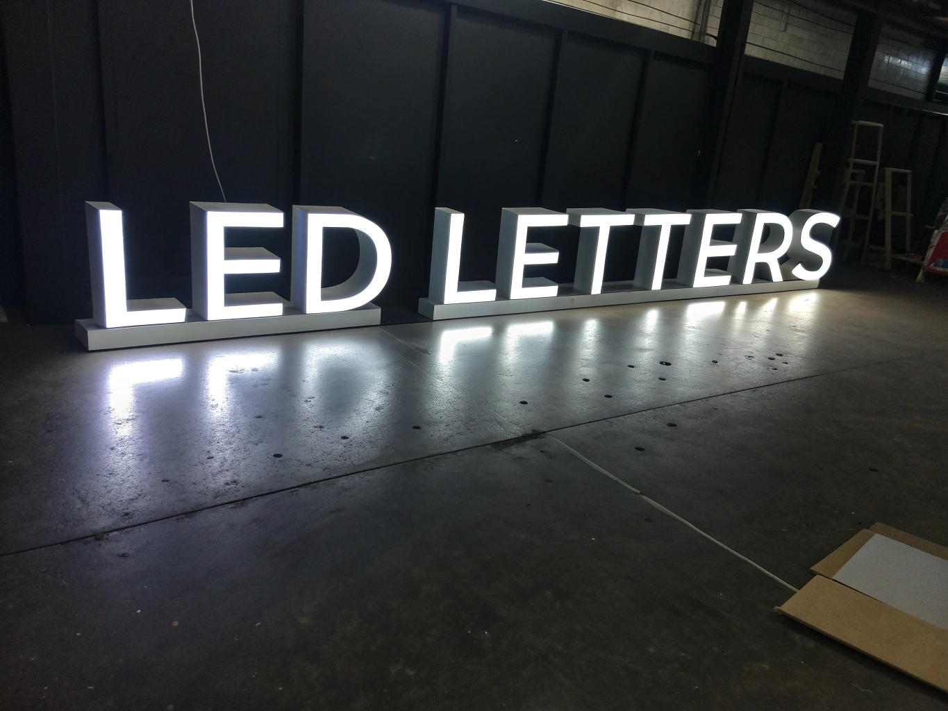 Litere volumetrice cu LED cald montate pe cărămidă